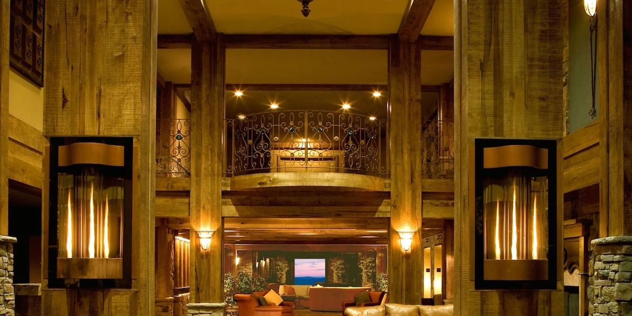 Cozy rustic lodge interior with warm lighting and wooden beams.