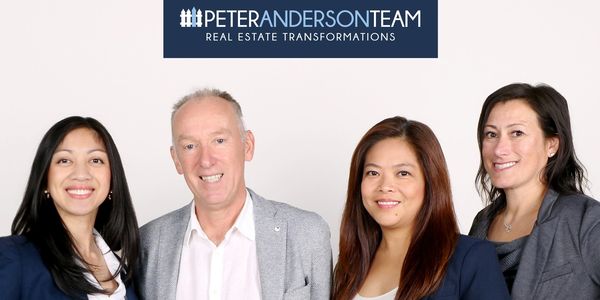 Professional real estate team posing together in business attire.