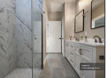 Primary Bathroom includes dual vanity, quartz countertop, walk-in shower, tile flooring , linen clos