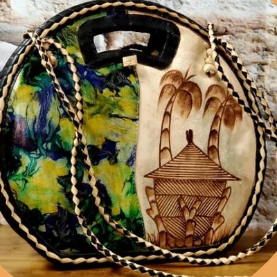 The image showcases a handcrafted African-inspired leather bag with a unique and artistic design.
