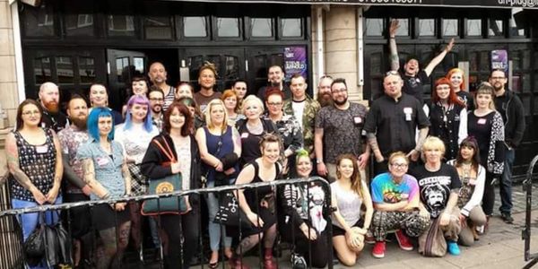 More than 30 people stood outside a club-style venue. Posed in a group shot to celebrate a meeting