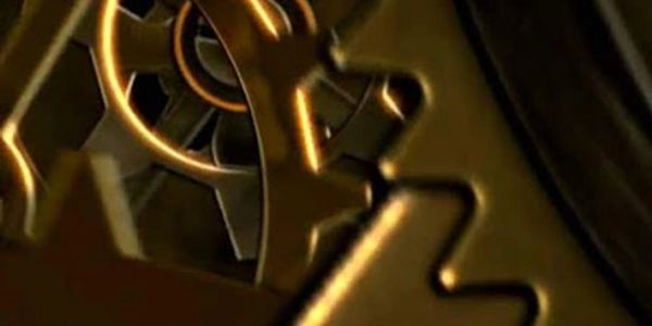 Close-up of interconnected golden clock gears in motion.