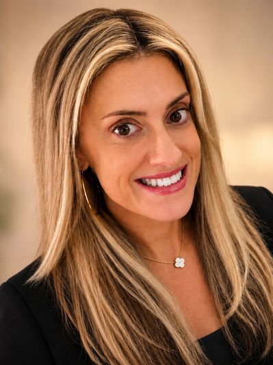Smiling woman with blonde hair and a black top.