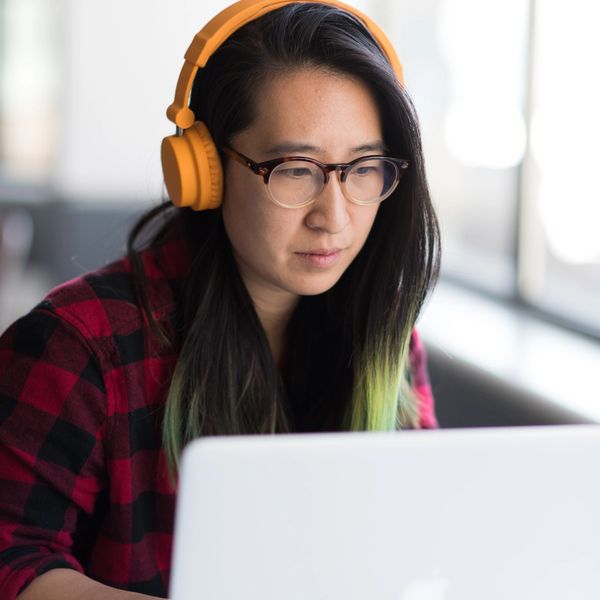 person with headphones using laptop