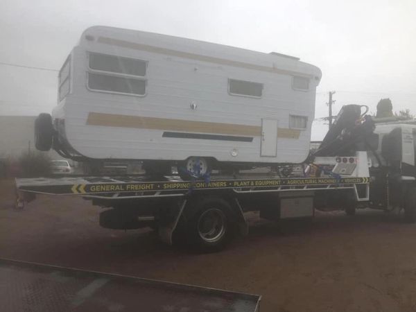 Tow truck at work taking a Caravan in for repair