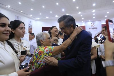 Encuentro afectuoso entre una mujer mayor y un hombre en un evento social.