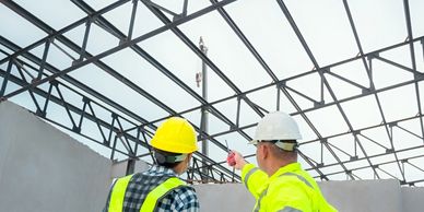 two workers inspecting the structural work of a building 