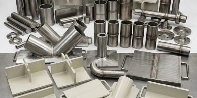 Various stainless steel pipes and fittings arranged on a table.
