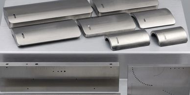Various sleek metallic parts laid out on a metallic surface.