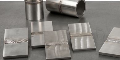 Various metal weld samples on a flat surface.