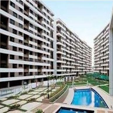 Modern apartment complex with a swimming pool and landscaped courtyard.