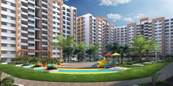Modern apartment complex with a playground and green landscaping under a clear sky.