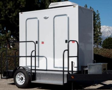 Portable restroom trailer with two doors on a trailer.