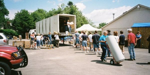 People unloading a truck with donations or supplies.