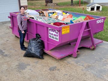 10 Yard dumpster with woman standing next to it.