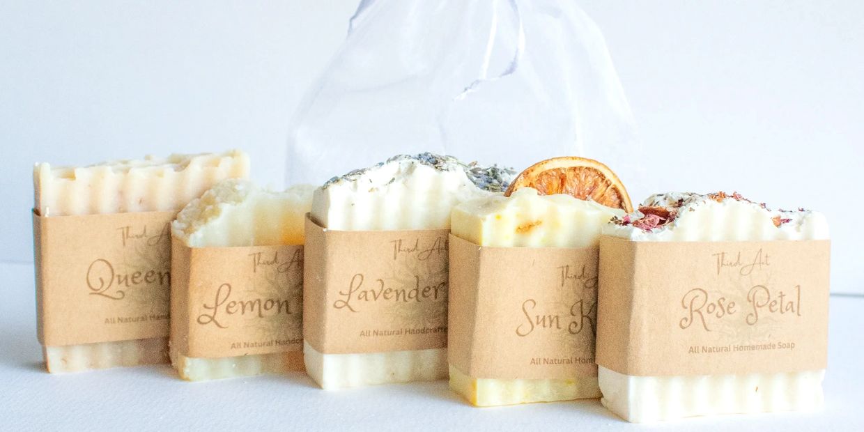 Five bars of natural handmade soap with different scents and decorative toppings.