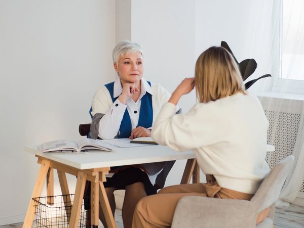 Two women talking at a table.