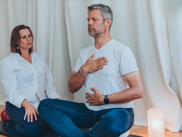 Man and woman meditating indoors.