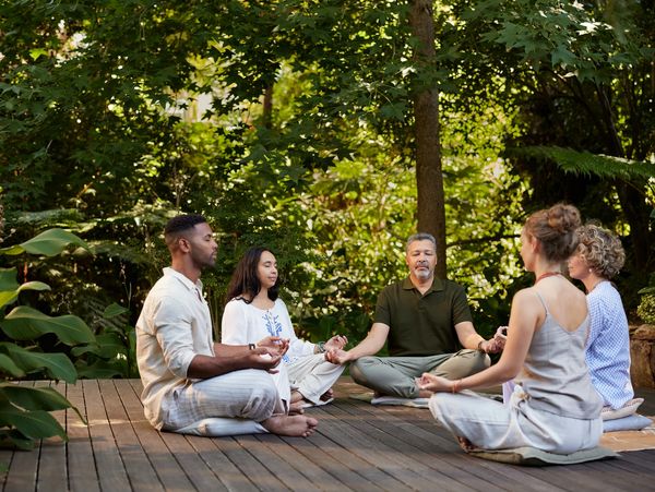 Group of people sitting in a circle outdoors