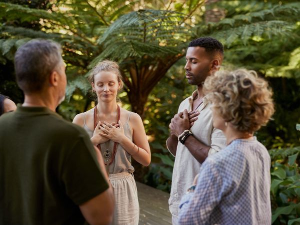 Group of people meditating outdoors."