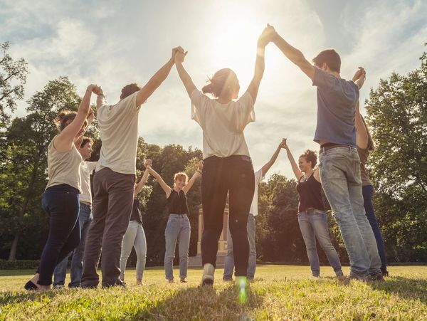 Group of people raising hands joyfully.
