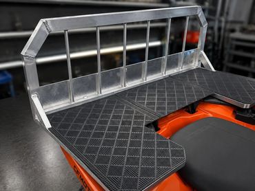 Custom aluminum rear rack with textured rubber mat for ATV.