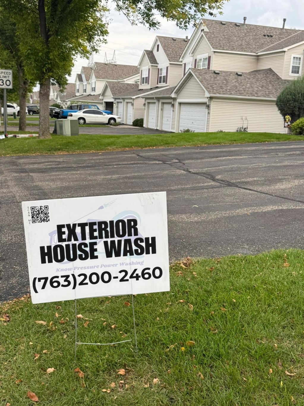Yard sign advertising exterior house wash service with contact number.