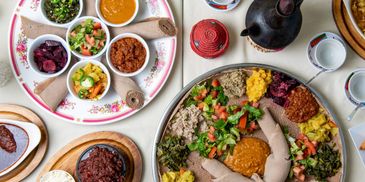 Traditional Ethiopian meal with injera and various colorful stews and vegetables.