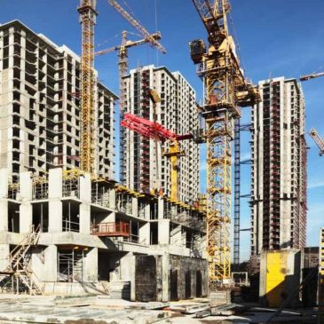 High-rise building construction site with cranes.