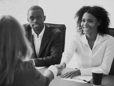 A woman shaking another woman's hand with a man sitting next to her. HR business subscription.