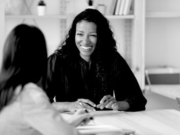 A woman coaching a woman at a desk