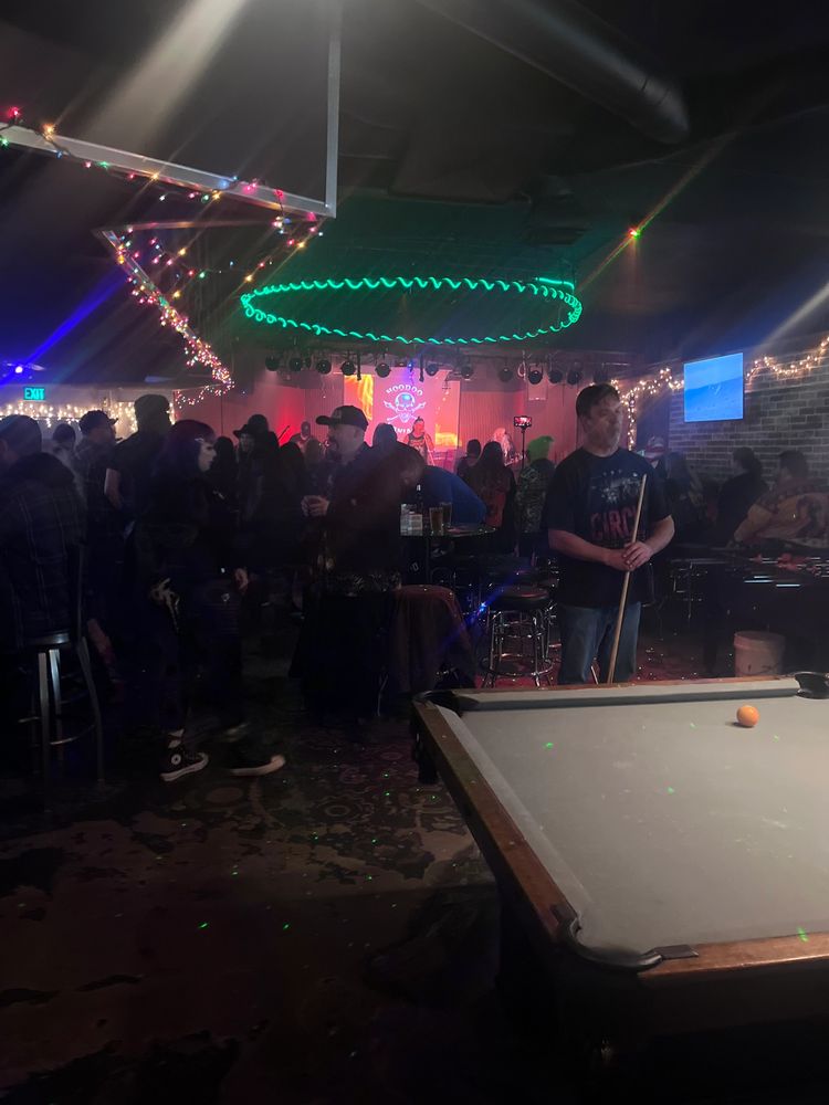 Bar scene with neon lights and pool table.