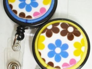 Badge reel has colorful flower designs with matching cording on a black badge reel