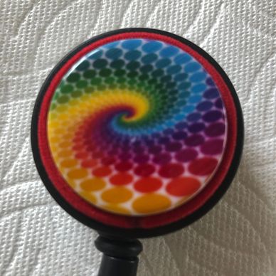 ID Badge reel has multiple colored rainbow design with red cording on black badge reel