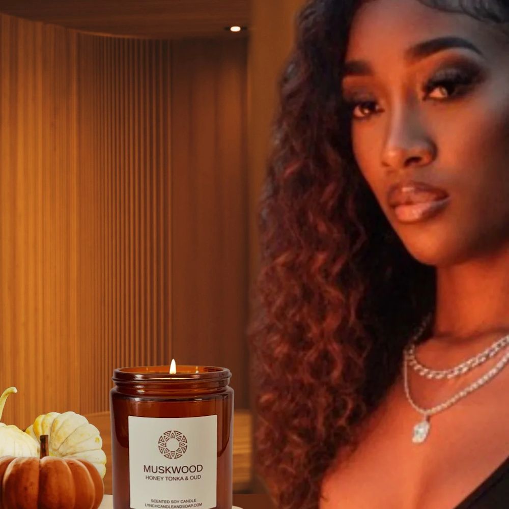 Aliyah sitting at table in front of a musk wood candle with two pumpkins next to the candle.