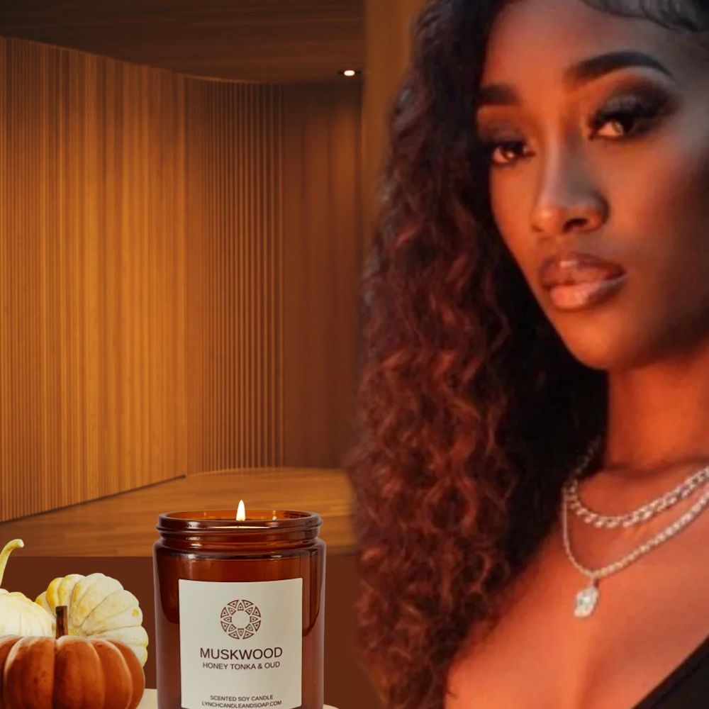 Aliyah sitting at table in front of a musk wood candle with two pumpkins next to the candle.