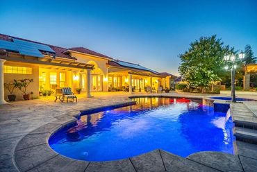 Elegant house with a glowing swimming pool at twilight.