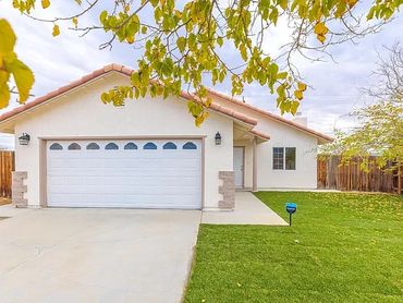 Single-story house with a white garage door and green lawn.