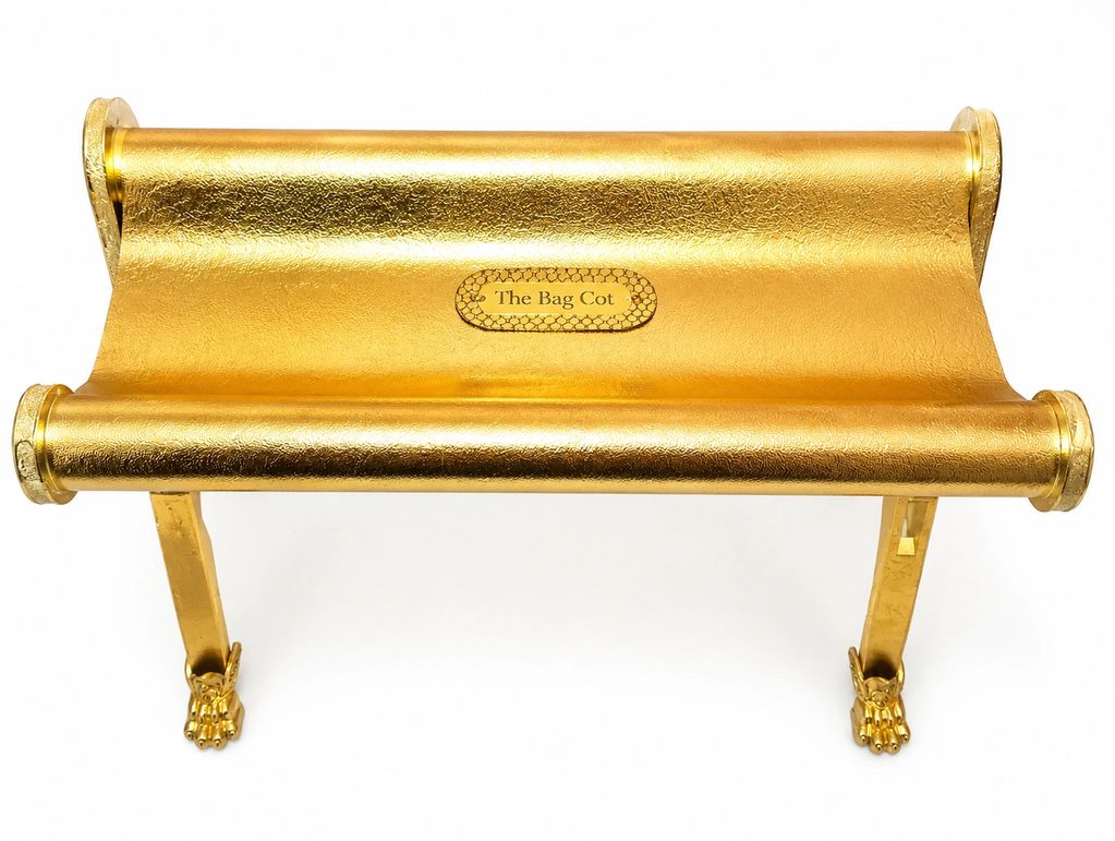Golden bag cot with claw feet and a label.