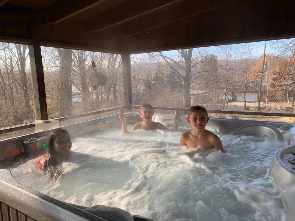 Cousins in a hot tub with a view of the Lake Keomah. This cabin is for rent for families to enjoy!