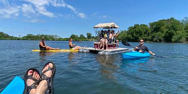 Two of the four kayaks and the pedal pontoon boat out on the lake with guests at The Cabin.