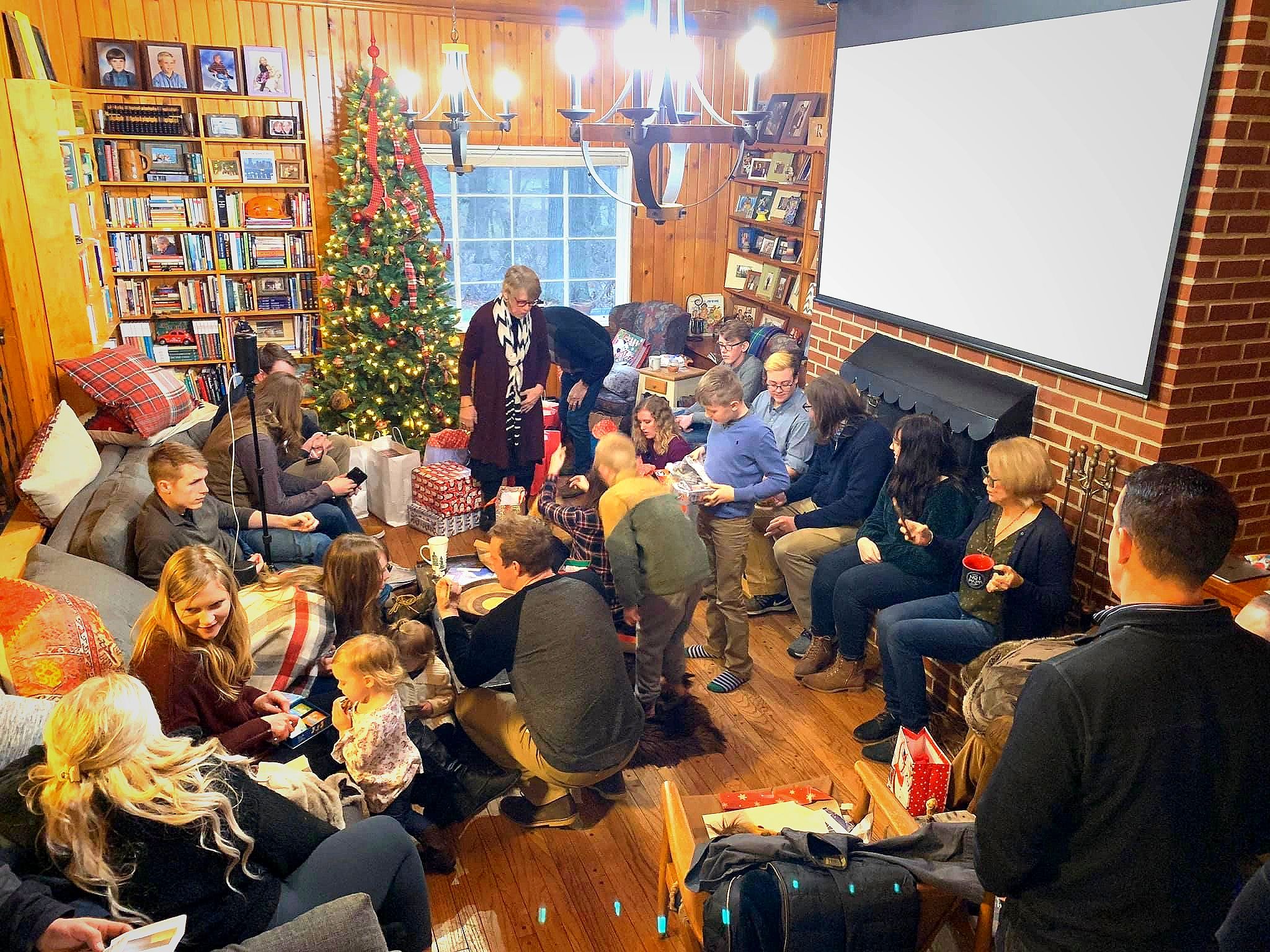 Family gathering to open Christmas gifts from grandpa and grandma in the great room at the cabin.