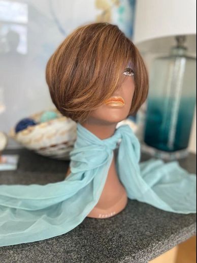 Mannequin head with a short brown wig and light blue scarf.