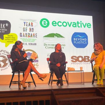 Three women on stage discussing sustainability and environmental topics in a panel setting.