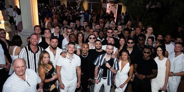 Large group of people posing at a nighttime outdoor party.