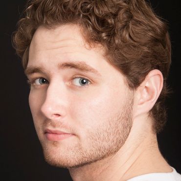 Headshot of young man looking over his shoulder