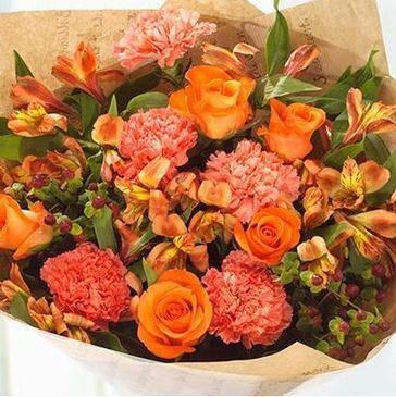 Bright orange and peach floral bouquet with green foliage.