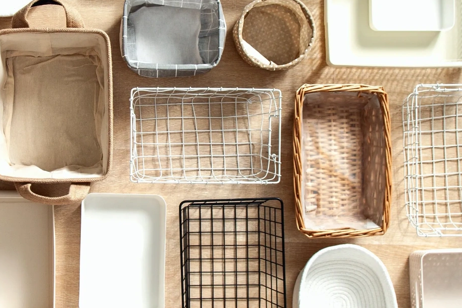 Various empty baskets and containers arranged on a wooden surface.