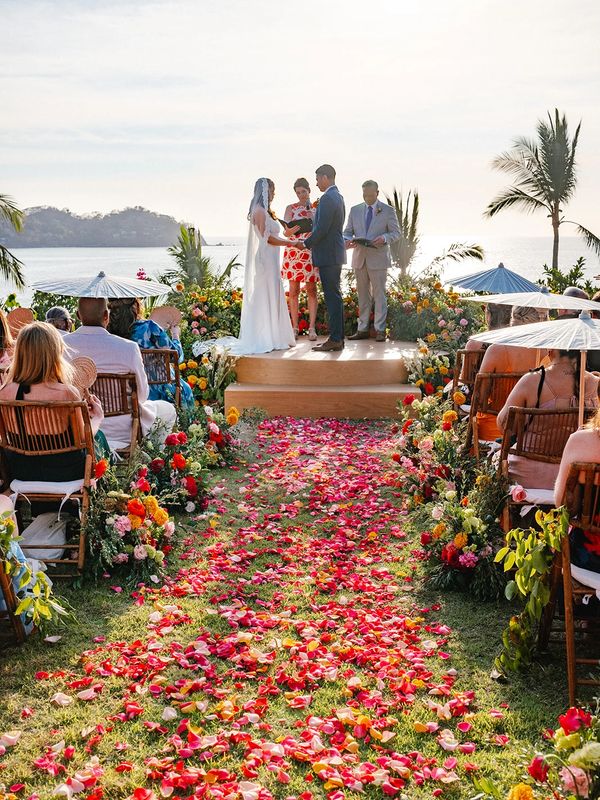 Colorful floral ceremony on elevated stage overlooking ocean in Sayulita Mexico