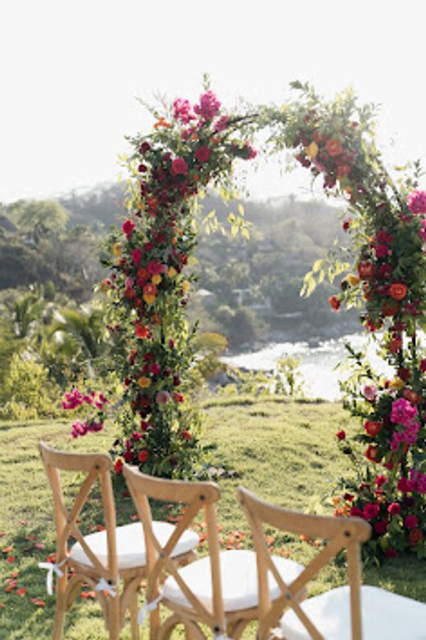 Oceanside wedding at Don Pedro's Palapa in Sayulita, Mexico. Gorgeous red and orange garden  florals
